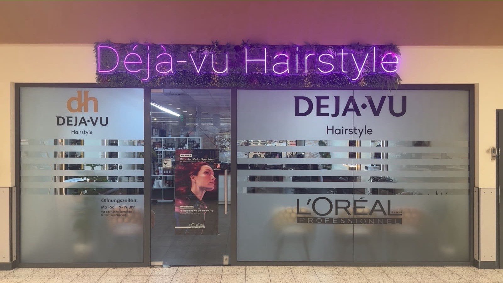 Eingang von Déjà-vu Hairstyle mit pinkem Neon-Schriftzug und L'Oréal-Professionnel-Beschriftung